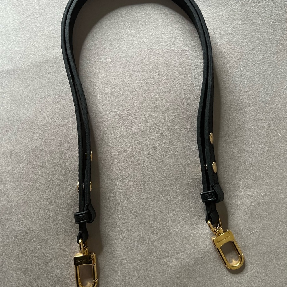 Louis Vuitton purse strap that goes to the “FAVORITE” purse.